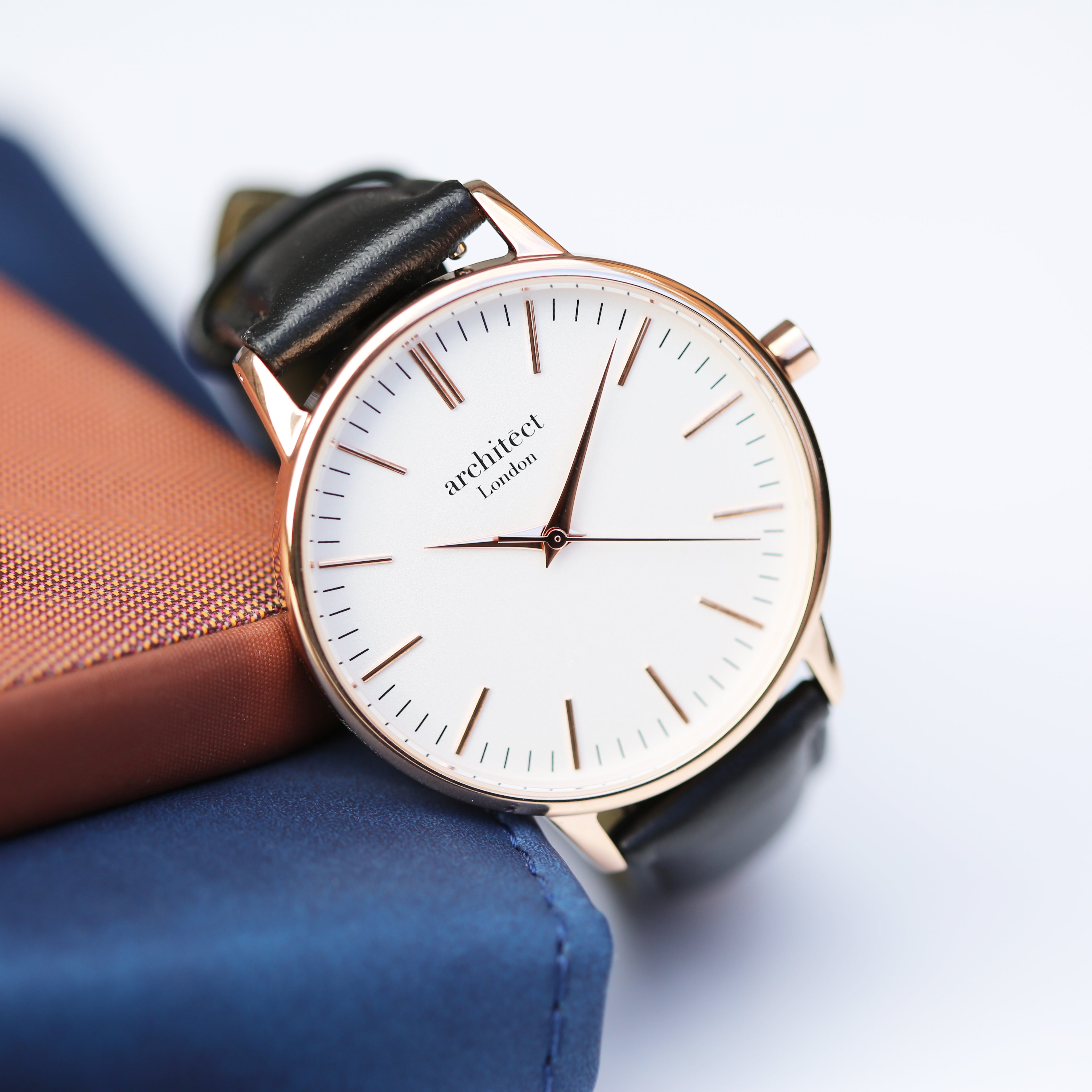Personalised ladies rose gold watch with black leather strap on soft fabric background