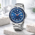 Silver watch with a blue dial on a light stone surface