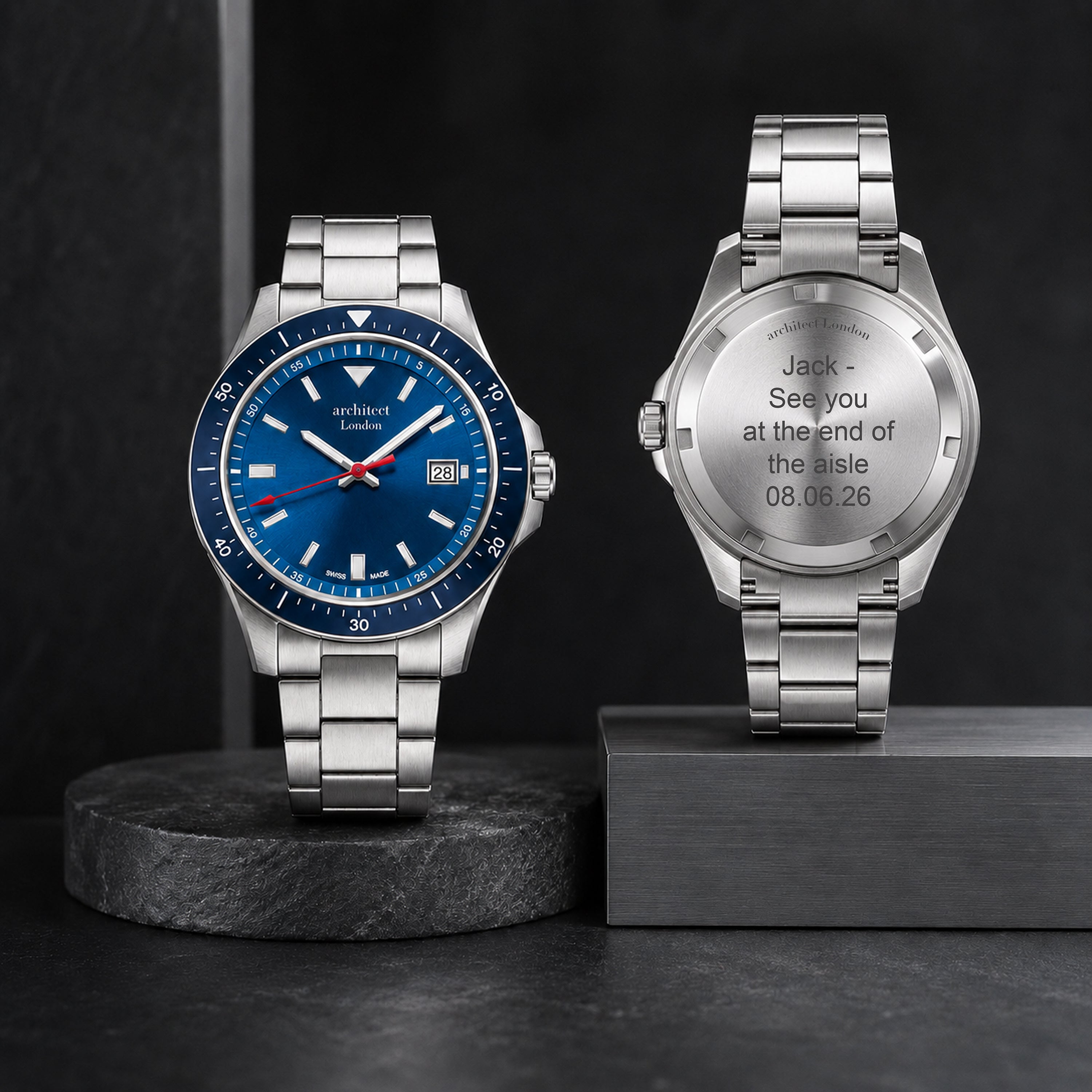 Two silver watches on black stands with a dark background