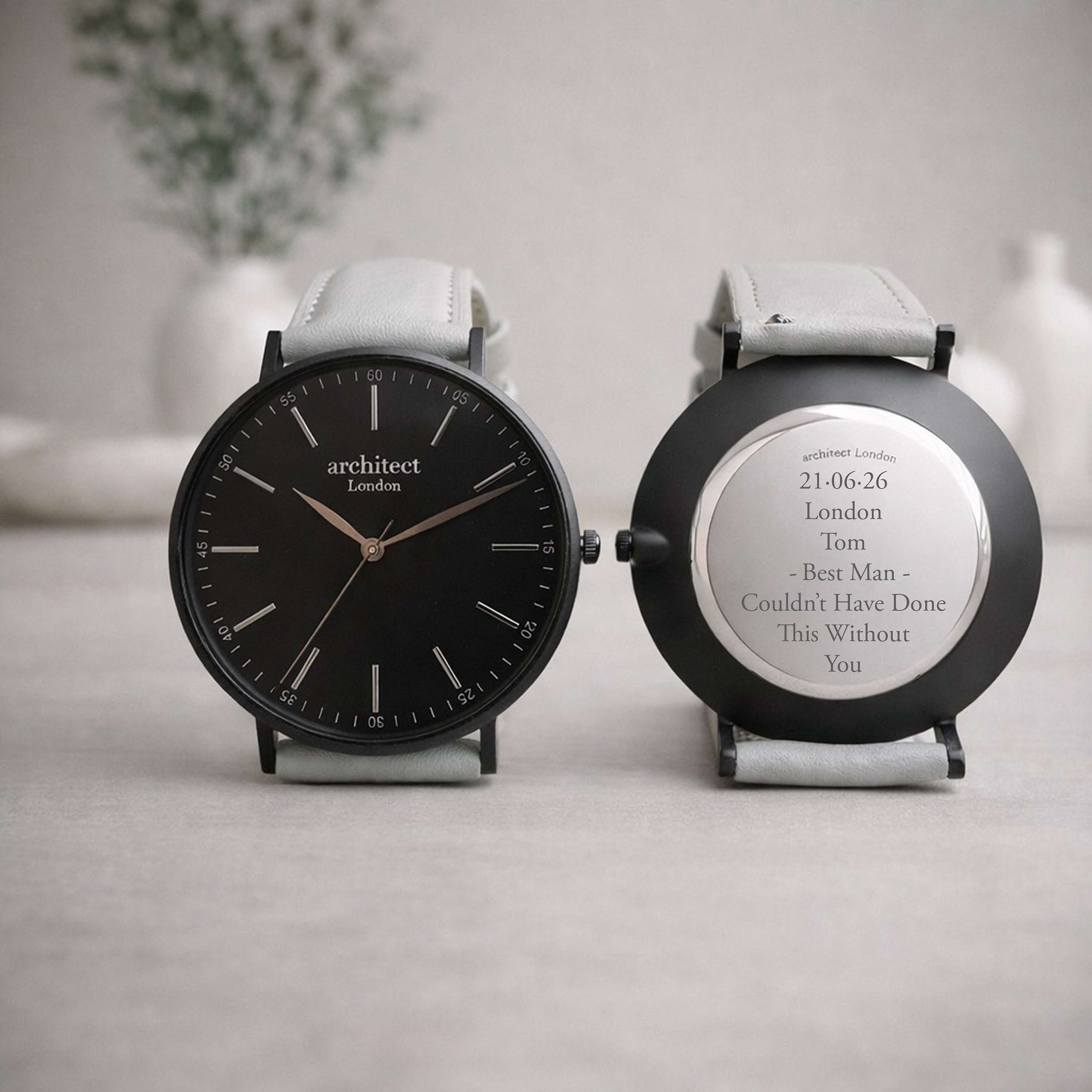 Personalised minimalist watch with light grey strap showing engraved back
