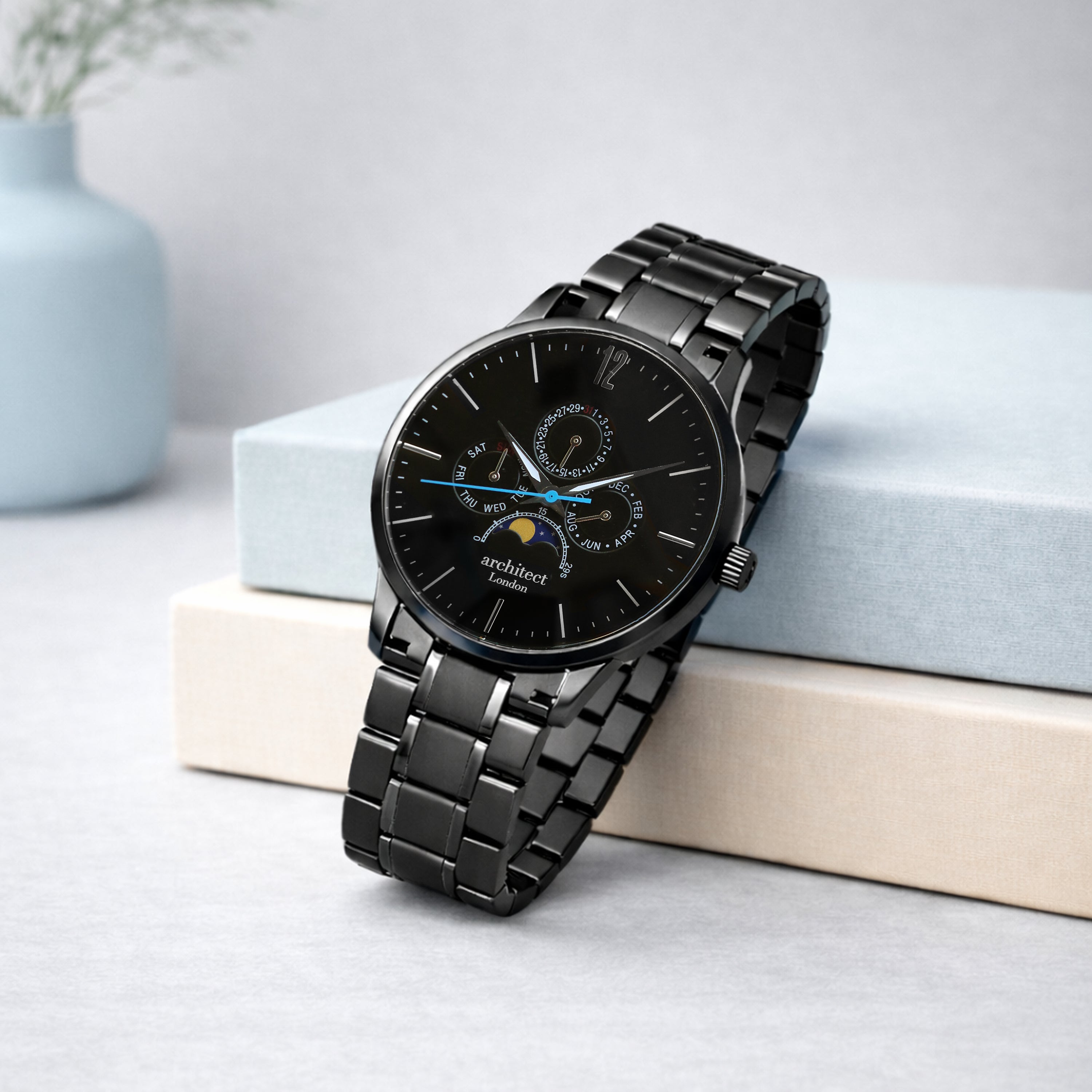 Black wristwatch with detailed face on a light surface engraved on the back