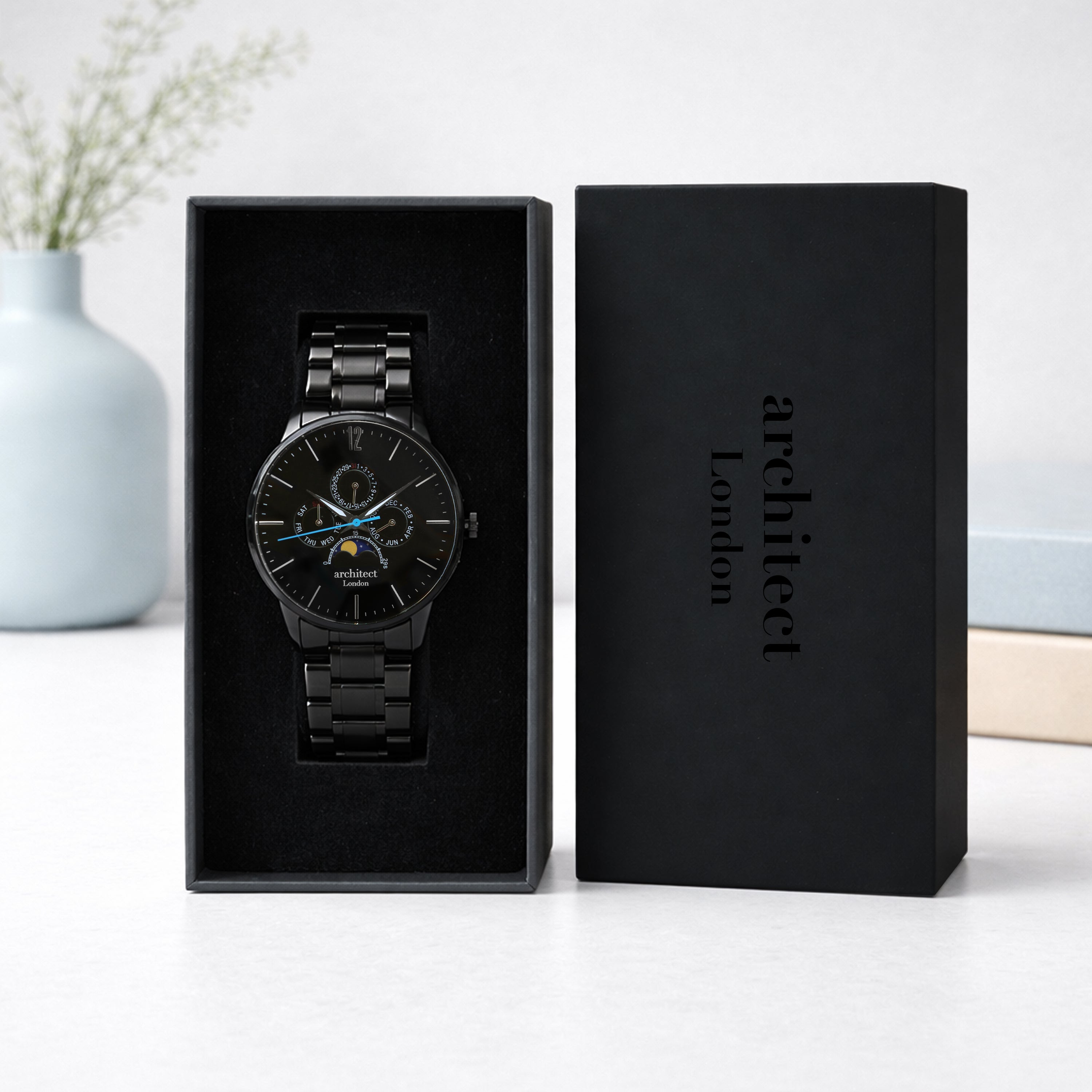 Black wristwatch in a box with 'Architect London' branding on a light background