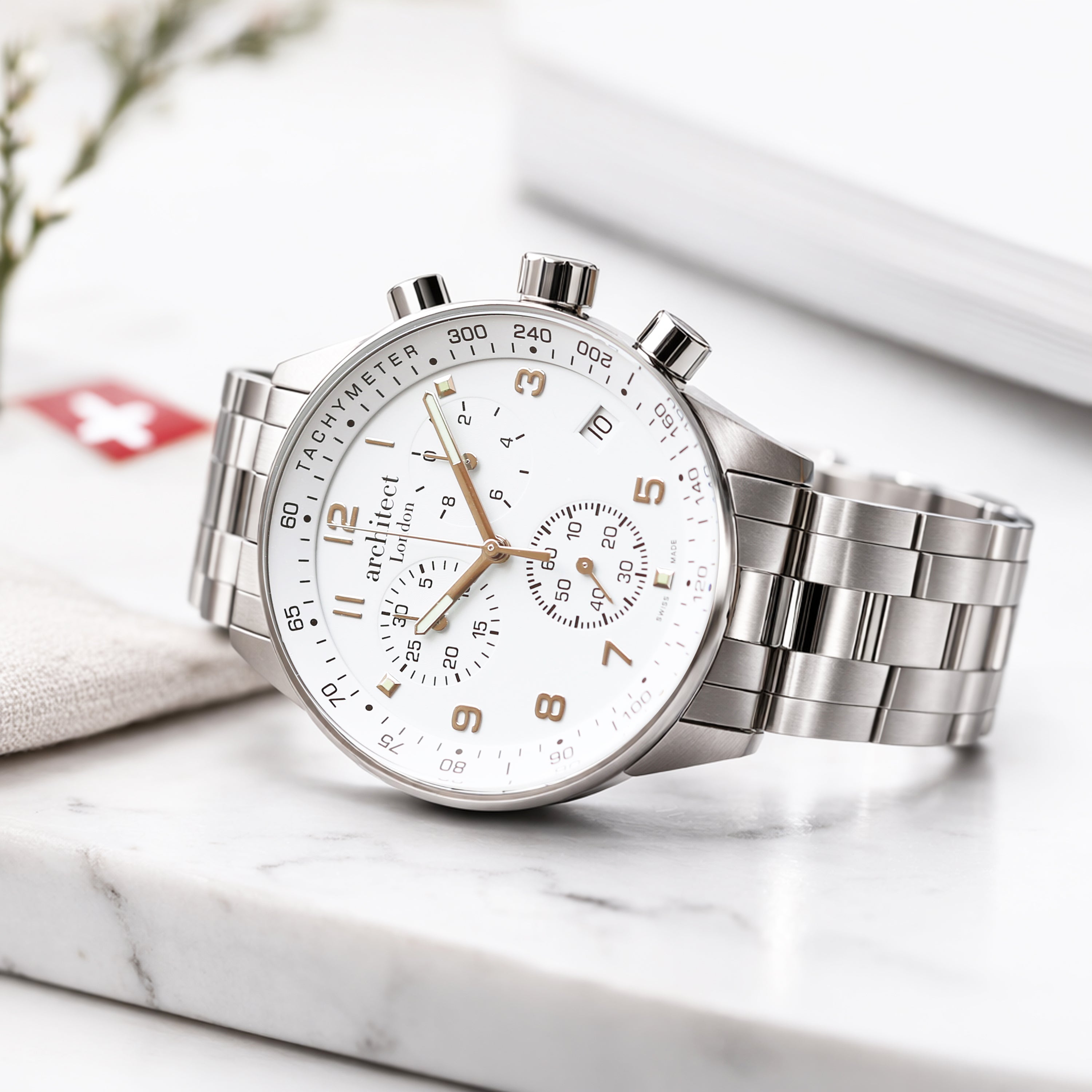 Silver wristwatch with detailed face on a marble surface. Swiss made personalised watch