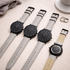 Four minimalist watches with light grey straps, one showing engraved back
