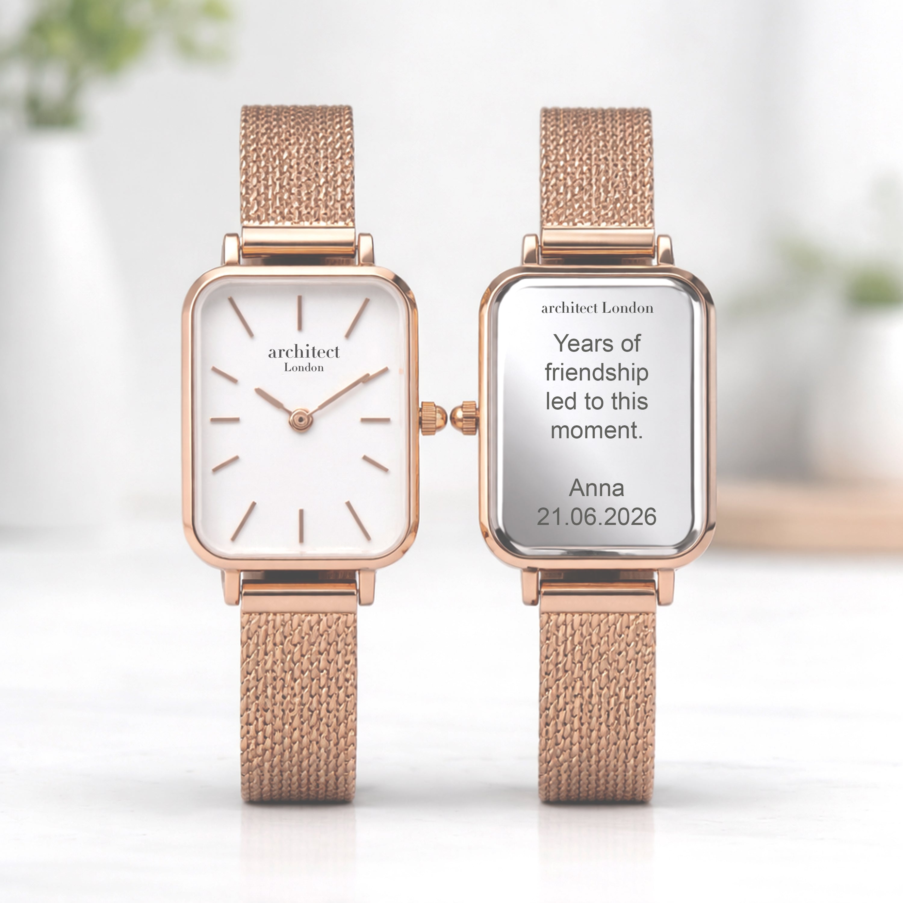 Two rose gold watches with white faces on a blurred background