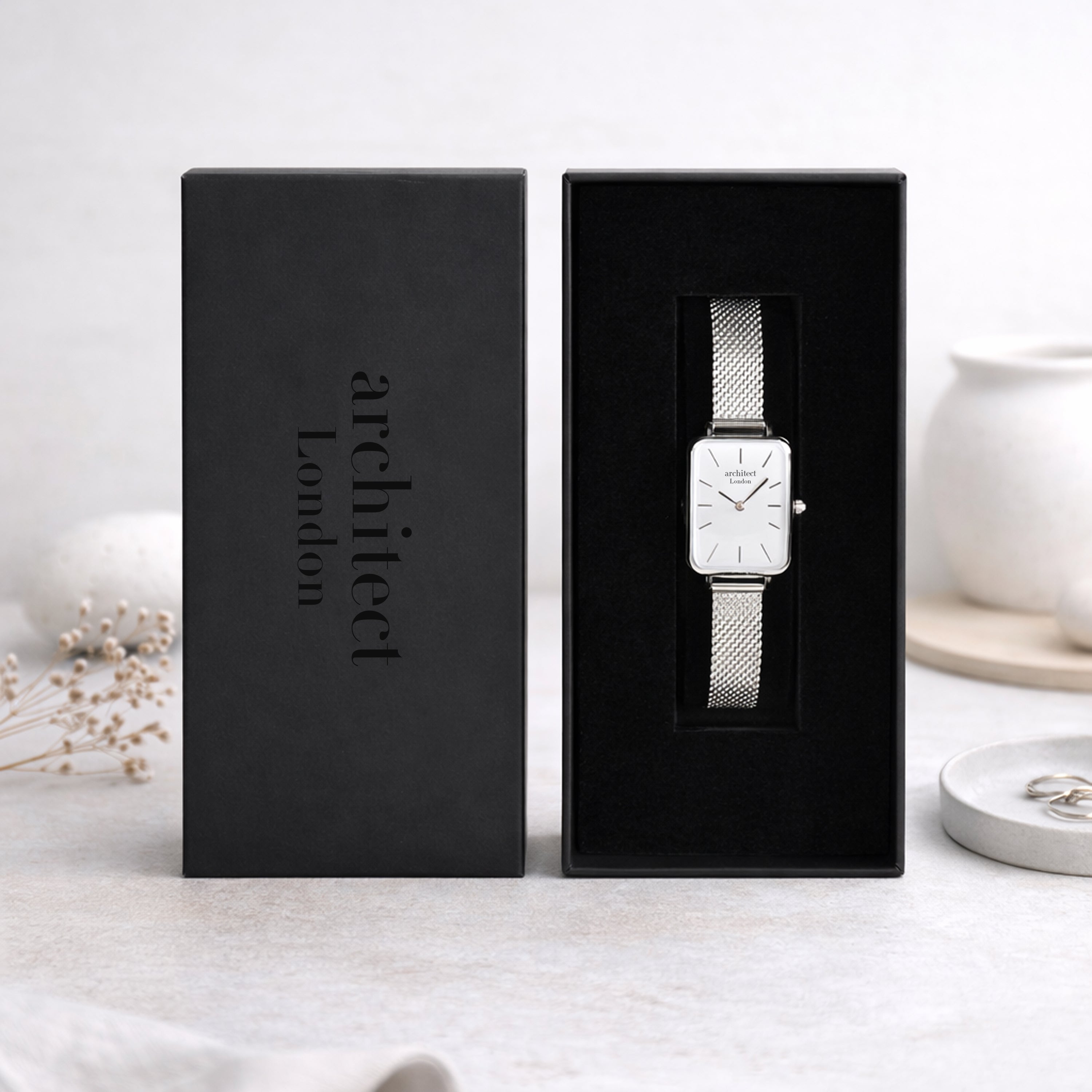 Silver watch in a black box with 'architect London' branding on a light background.