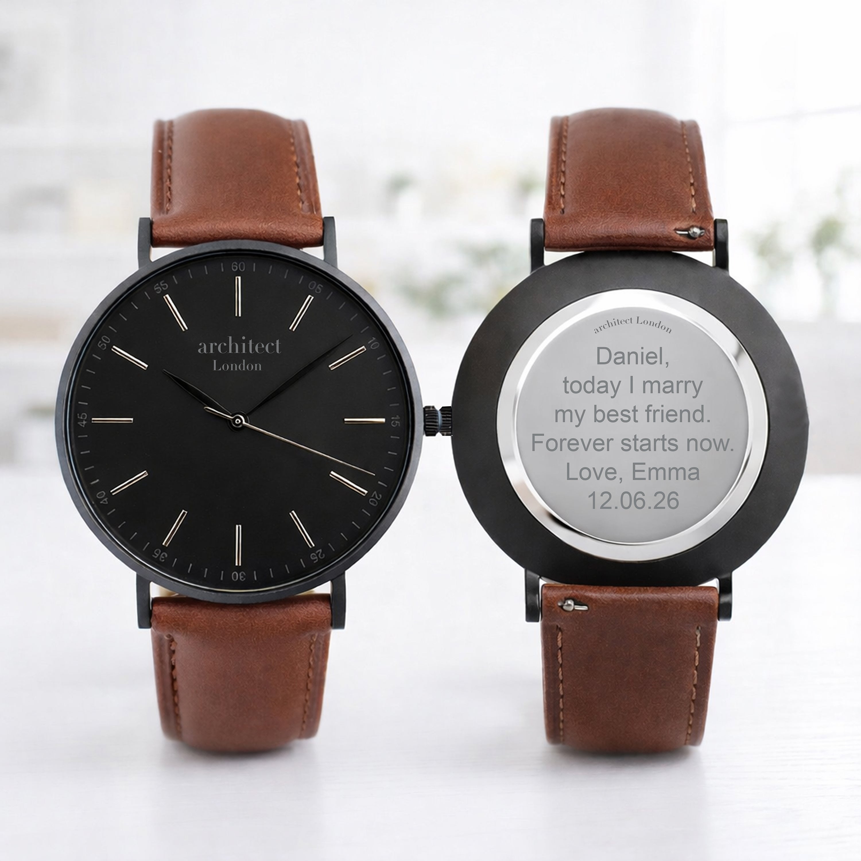 Two brown leather watches with engraved messages on a white background