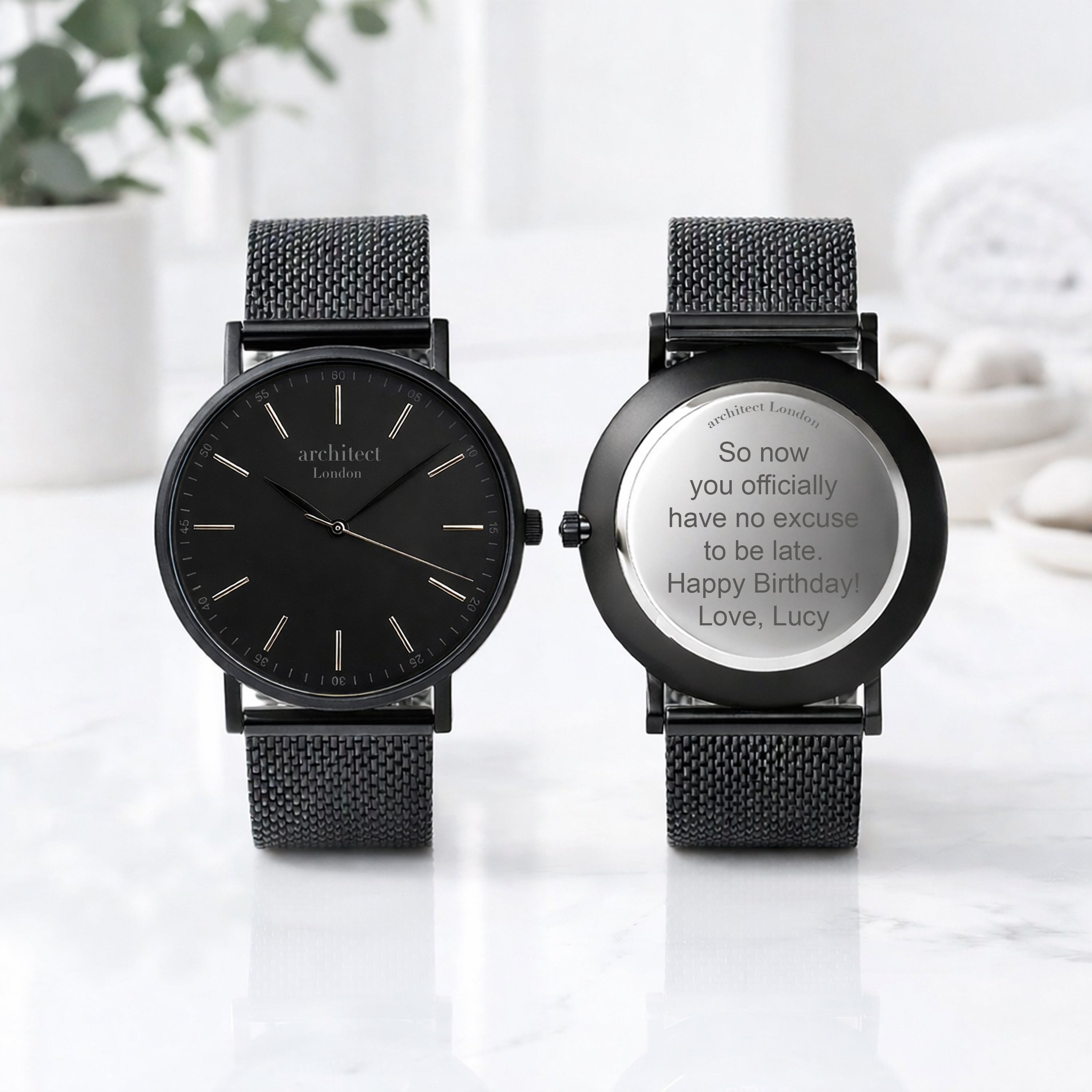 Two mens minimalist wedding watches, one showing engraving at the back