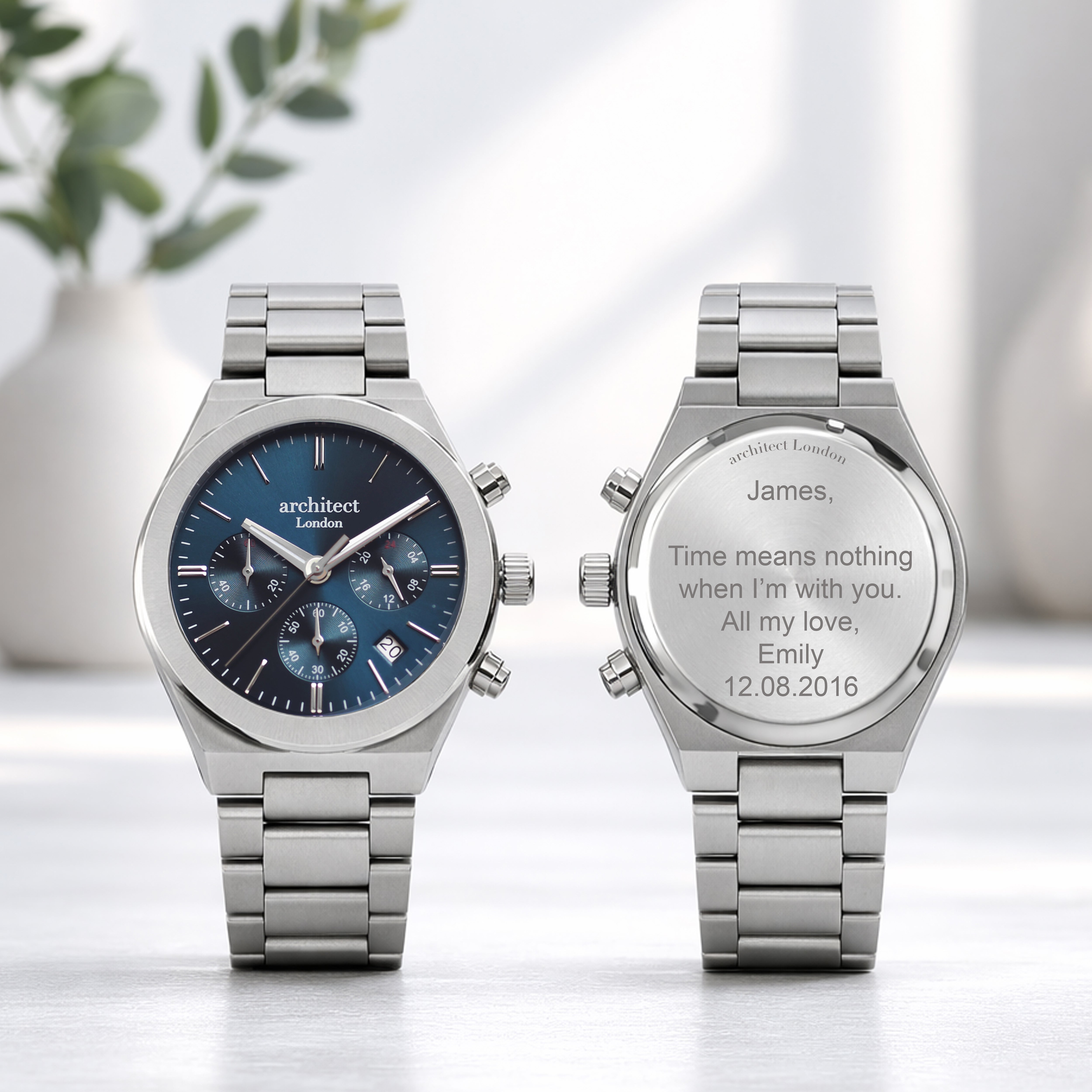 Two silver watches on a light background with engraved text.