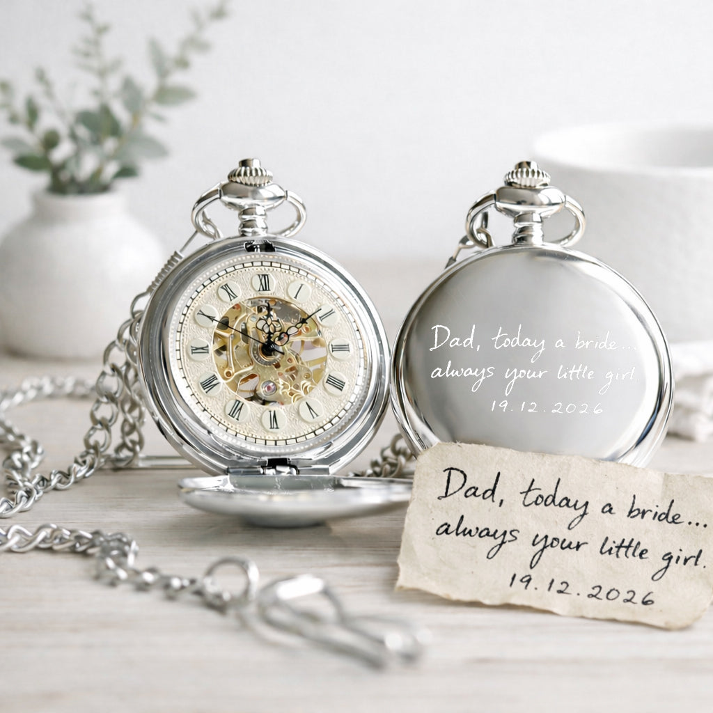 Two silver pocket watches with engraved messages on a light surface.