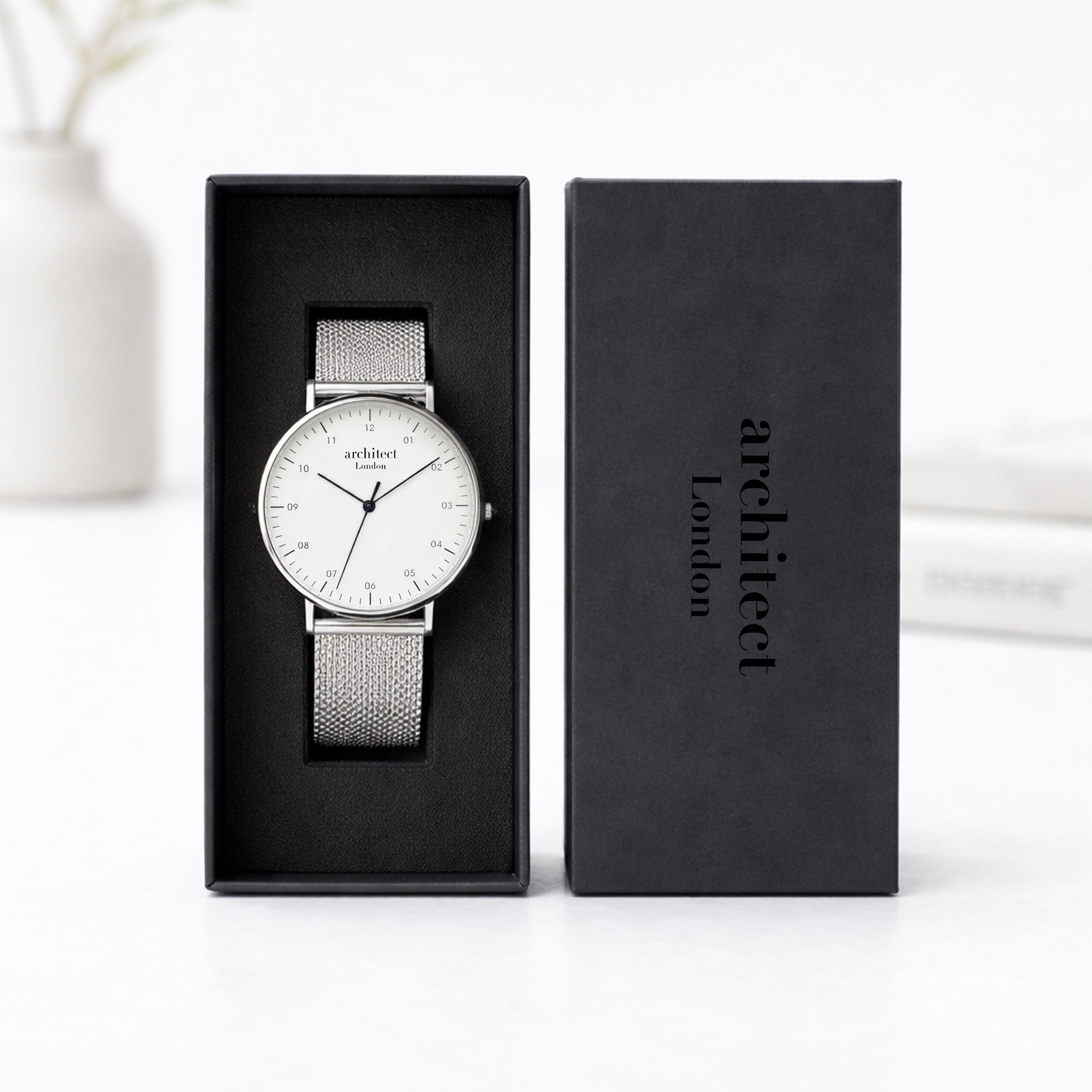Silver watch in a black box with 'architect london' branding on a white background